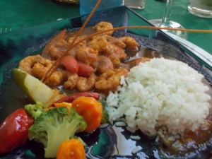 A plate showing a hearty meal of rice, vegetables, and shrimp.